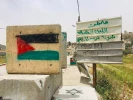 فلسطينيون يرسمون علم فلسطين على حواجز الاحتلال   2