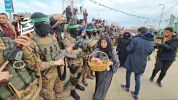 ریختن گل بر سر مجاهدان قسام از سوی  بانوی فلسطینی در مراسم تحویل اسرای اسرائیلی در دیر البلح در مرکز نوار غزه
 2