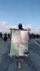 مقاتل من مقاتلي حماس يتجول حاملاً صورة محمد الضيف في ميناء غزة